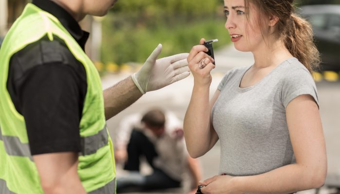 policeman-and-woman-during-breathalyzer-test-in-the-foreground-accident-victim