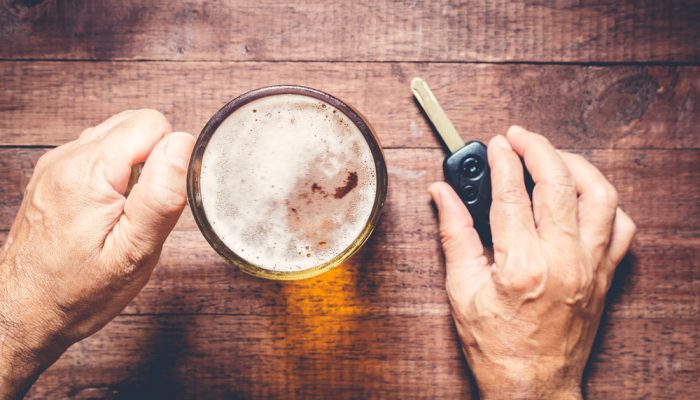 Man hand drinking beer and holding car keys