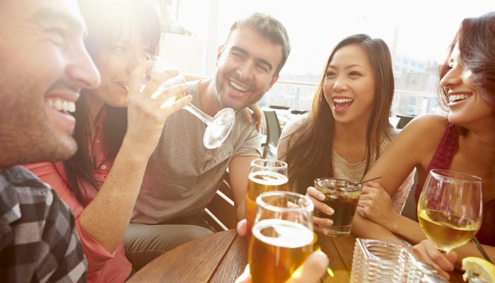 Group Of Friends Enjoying Drink At Outdoor Rooftop Bar